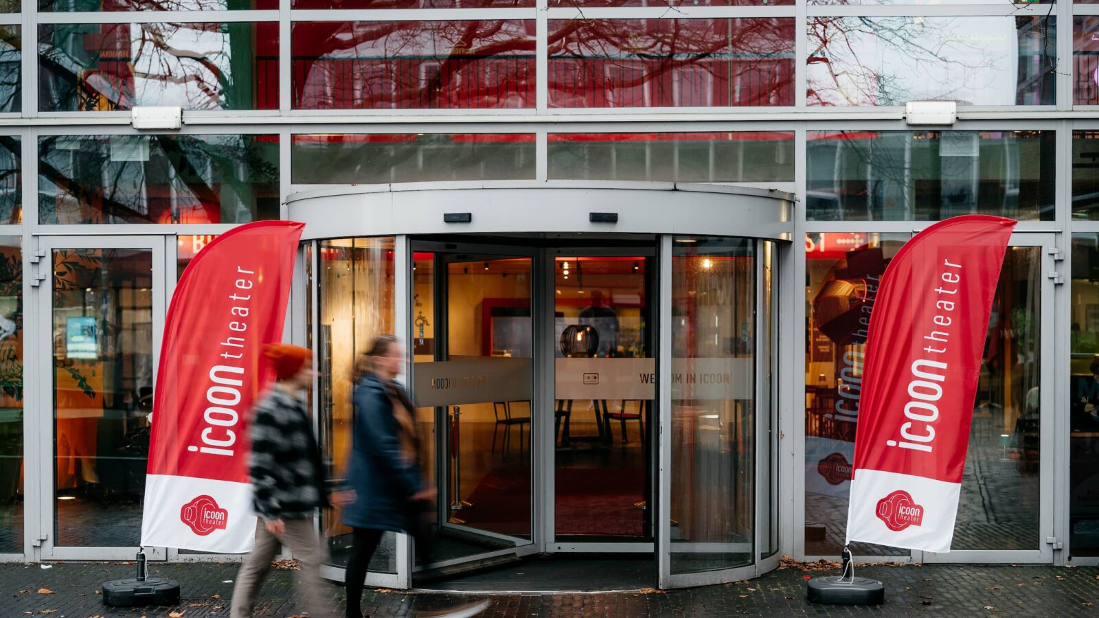 Foto van de ingang van het ICOONtheater in Amersfoort, waar mensen langslopen.